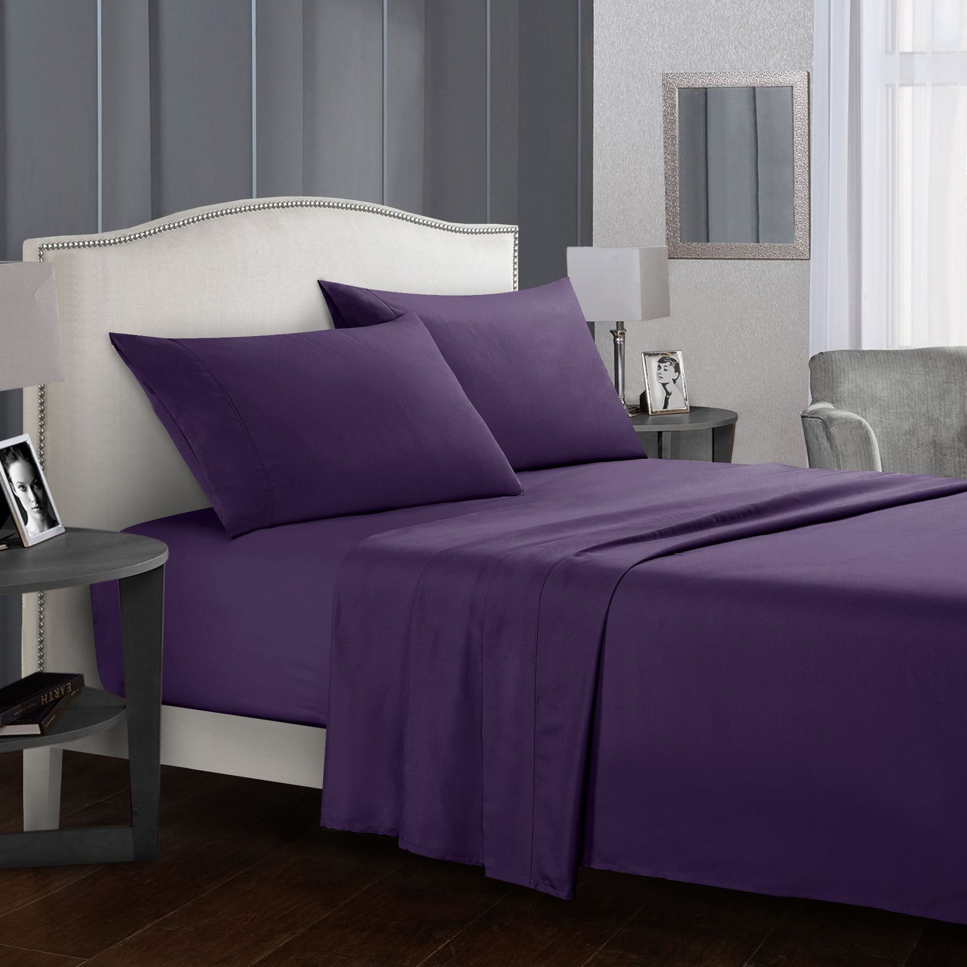 Purple bed sheets and pillows on a bed in a bedroom setting.