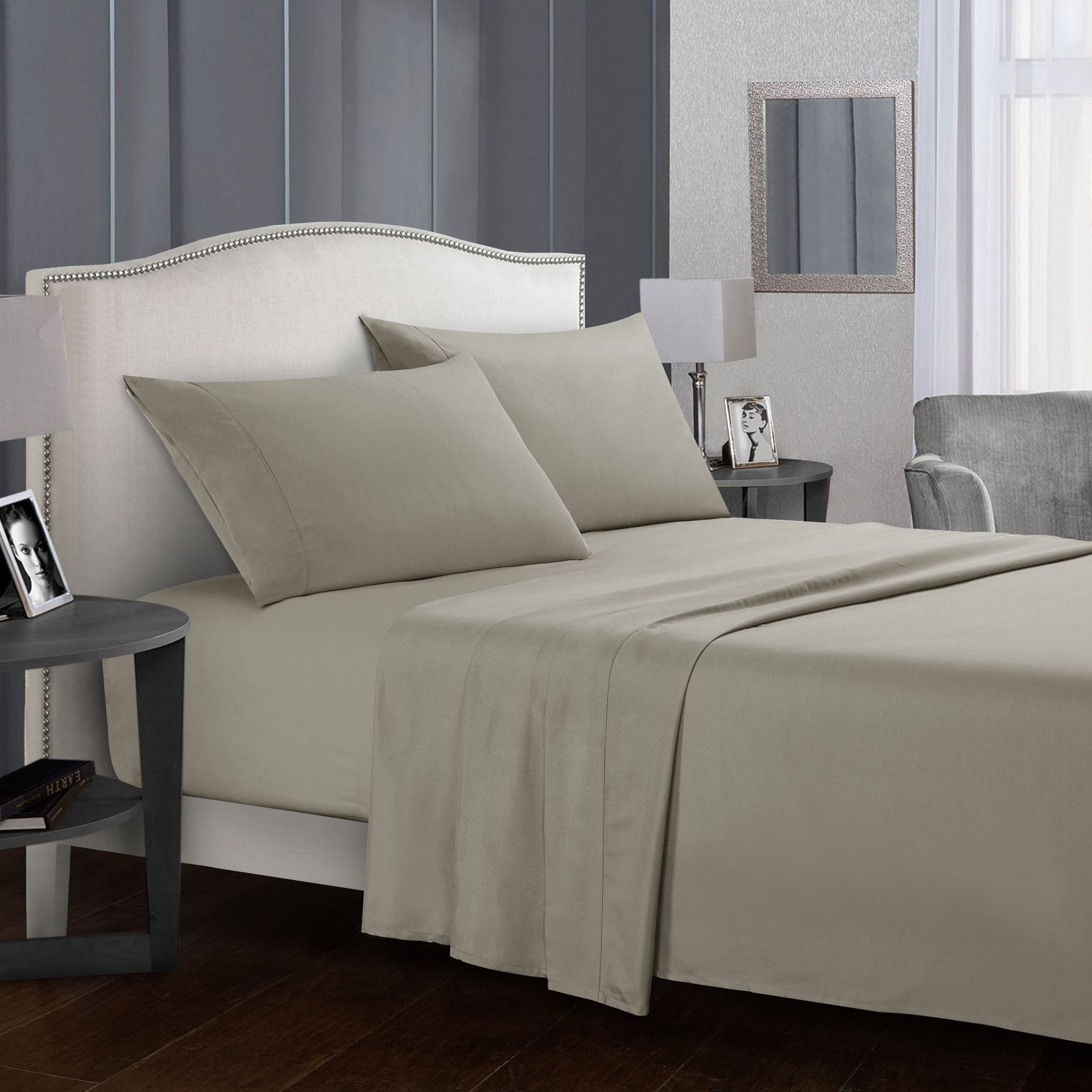 Neatly made bed with beige bedding in a bedroom setting.