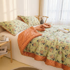Floral bedding with orange comforter on a bed