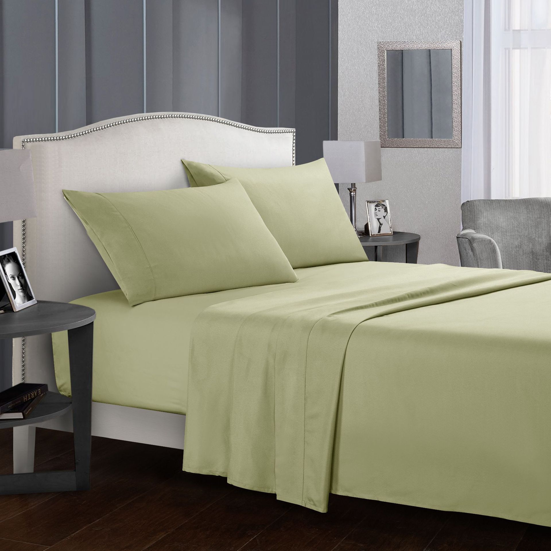 Green bed sheets and pillows on a bed in a bedroom setting.