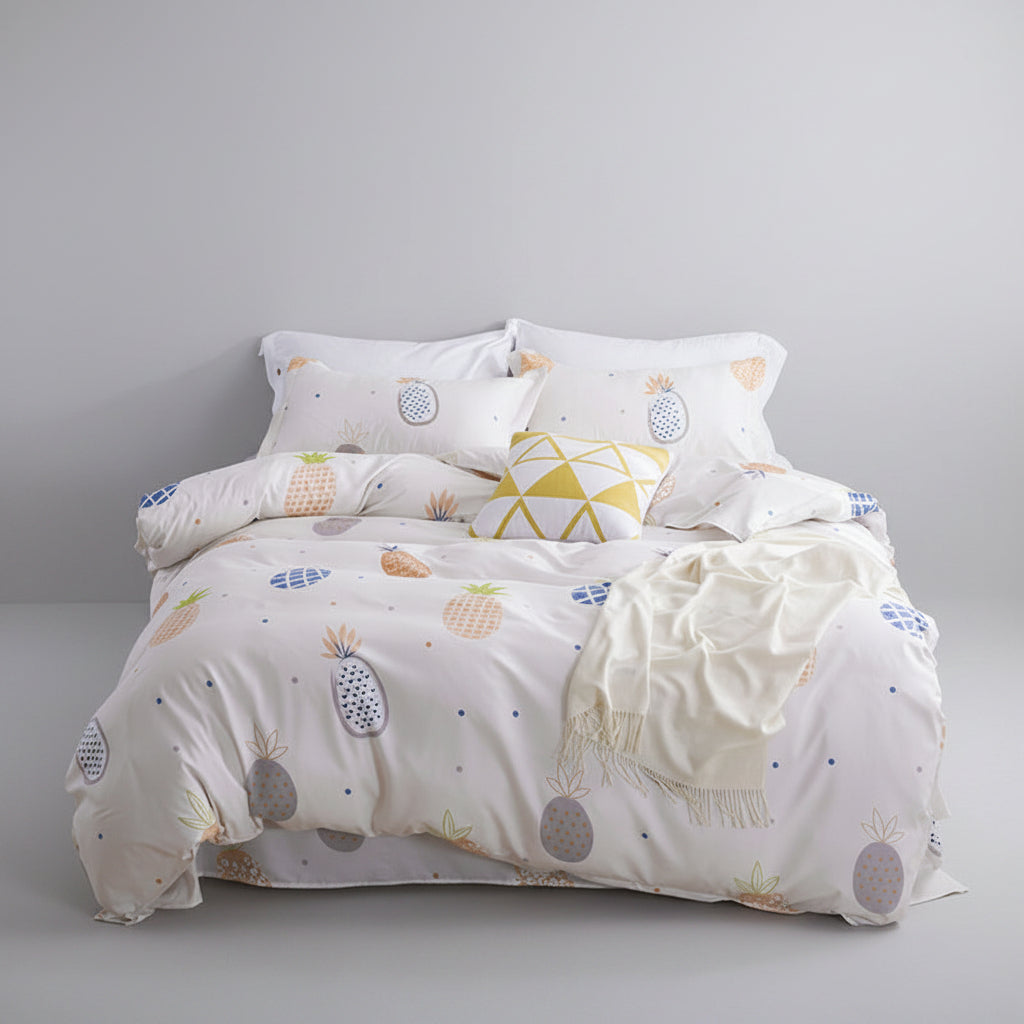 Bed with patterned bedding in a room with a lamp, plant, and decorative items.
