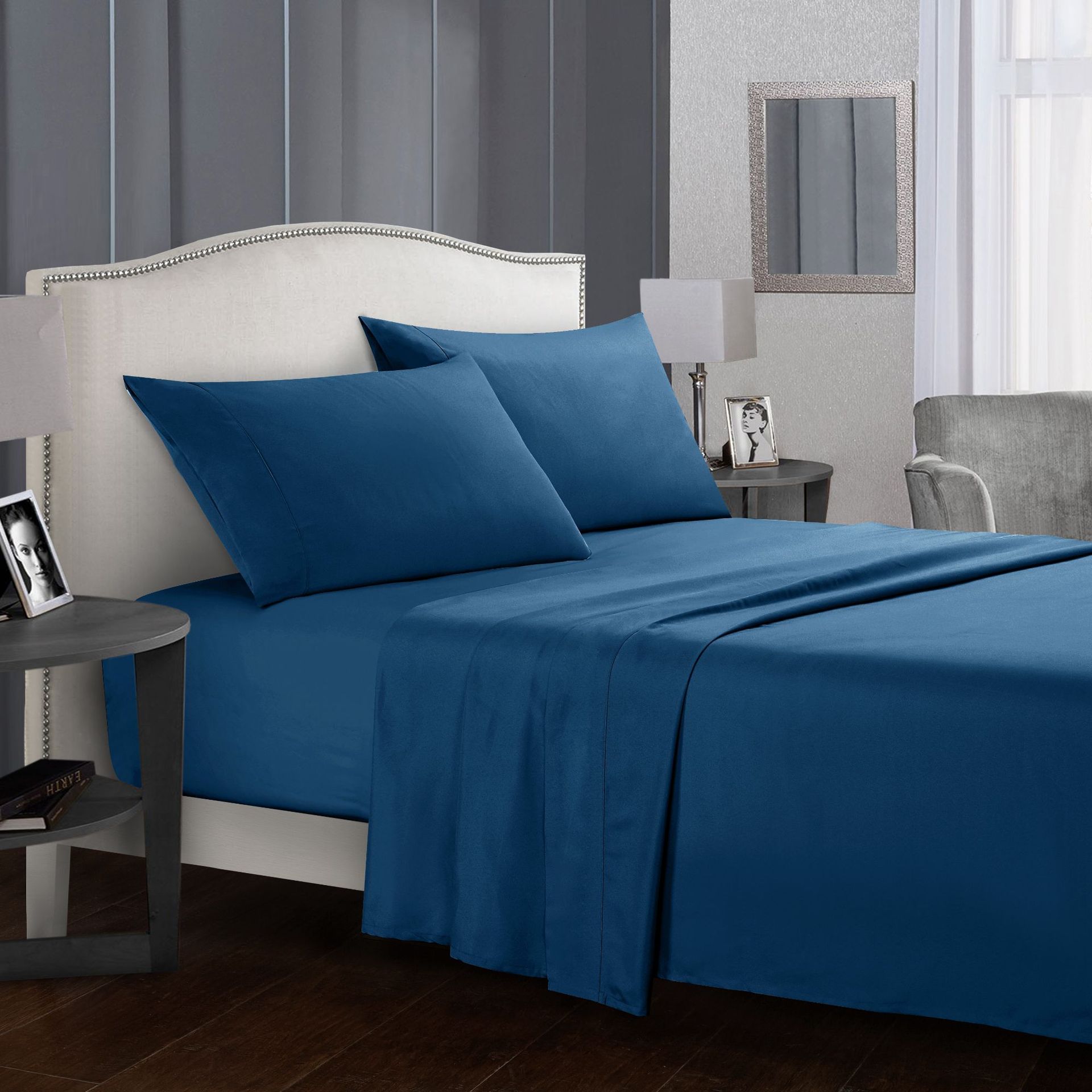 Blue bed sheets and pillows on a bed in a bedroom setting.