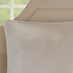 Close-up of a beige pillow on a sofa with a blurred green background