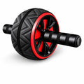 A black and red ab roller wheel exercise barbell with textured grips, shown on a white background with a small red 'Gift' badge and a gray mat below.