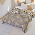 Geometric patterned throw blanket on a bed in a bright bedroom