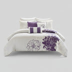 Bedroom with white bedding and purple floral patterns, featuring a bed and side table.